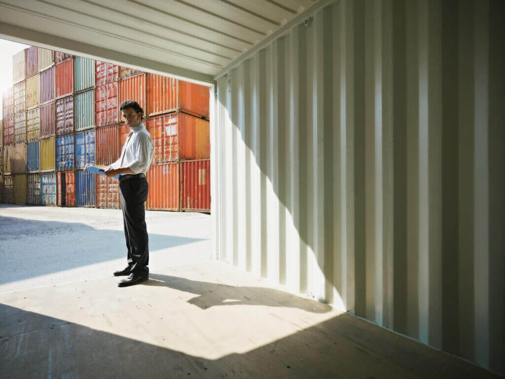 Business professional standing inside a shipping container