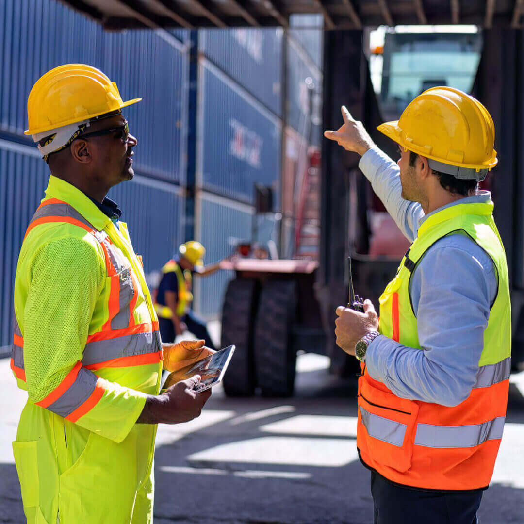 Warehouse worker standing beside a container lift truck
