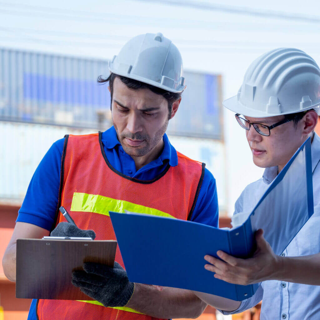 Container workers reviewing logistics documents